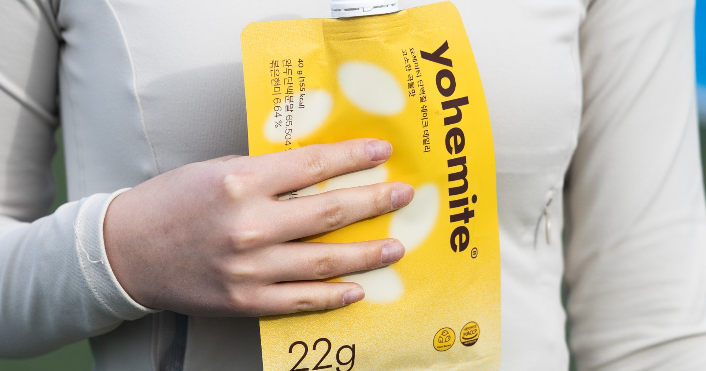 A runner holding a yohemite daily protein shake