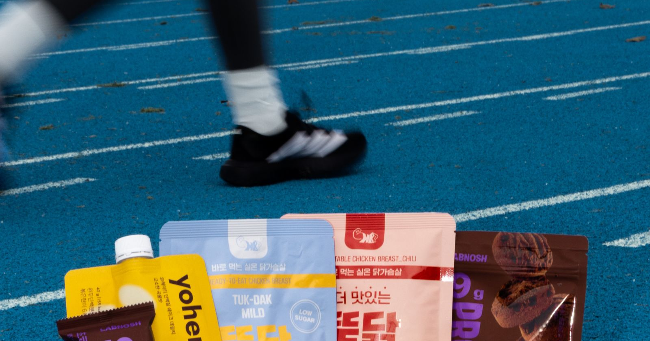 Runners on a track with Momentum fuelling products in the foreground